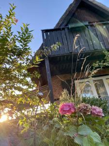 a house with some flowers in front of it at Reetdachhaus am See in Groß Sarau +11 photos