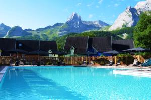 a large swimming pool with mountains in the background at ISKÖ CHALETS-HÖTEL, Col d'Aubisque in Gourette