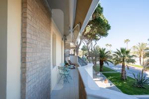 ロゼート・デッリ・アブルッツィにあるHomiday - OLIMPO Fronte Mare Luxuryの海とヤシの木の景色を望むバルコニー