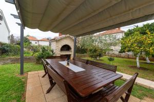 a wooden table with benches on a patio at Villa K&F Borik in Zadar