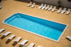 a swimming pool with white chairs and a swimming pool at DonAna 308 in Lagos