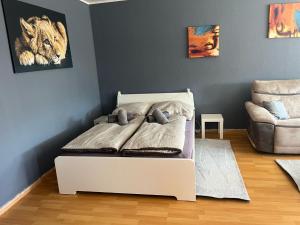 a bed in a room with a couch and a chair at Wohnglück 2 in Herten