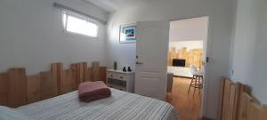 a bedroom with a bed and a desk and a window at Famara - Casa Marosenia in Güime