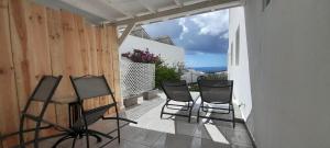 a balcony with chairs and a table on a balcony at Famara - Casa Marosenia in Güime