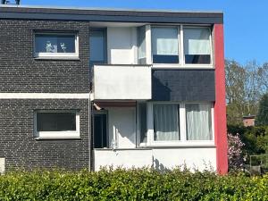 a building with two windows and a dog in the window at Wohnglück 2 in Herten