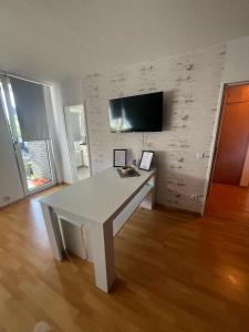 a white table in a room with a tv on a wall at Wohnglück 2 in Herten