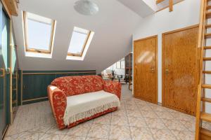 d'un salon avec une chaise rouge et des fenêtres. dans l'établissement Plac Neptuna Bright Studio with Balcony by Noclegi Renters, à Międzyzdroje