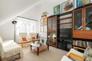 Il comprend un salon doté de meubles et d'une télévision. dans l'établissement Plac Neptuna Bright Studio with Balcony by Noclegi Renters, à Międzyzdroje