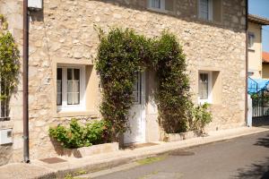 a stone building with a white door and plants at Casa Vacacional Patro in Nueva de Llanes