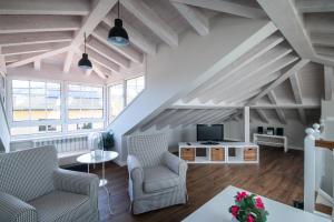 a living room with two chairs and a tv at Casa Vacacional Patro in Nueva de Llanes