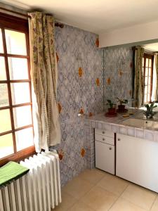 a kitchen with a white radiator in a room at Les Favouilles, le gîte pour 15 personnes in Dauphin