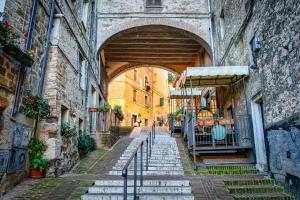 an alley with an archway in an old building at Appartamento Piccola Perugia in Perugia