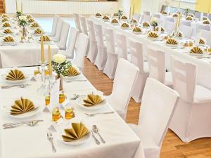 a row of white tables and chairs in a room at Gasthof goldener Engel in Kemnath