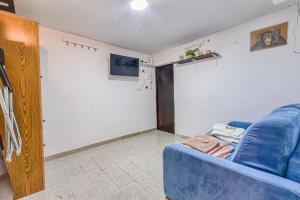 a living room with a blue couch and a tv at Appartamento Piccola Perugia in Perugia