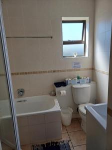 莫塞尔湾Hartenbos - Bayview 230m from beach的带浴缸、马桶和水槽的浴室