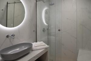 a bathroom with a sink and a shower with a mirror at Little Diamond in Megalokhori