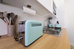 a kitchen with a blue appliance on a counter at Casinha da Rosa in Nazaré +33 photos
