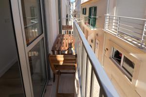 a balcony with a bench on the side of a building at Casinha da Rosa in Nazaré