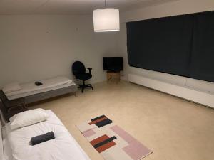 Una sala de estar con un televisor grande y un sofá. en Home for work crew Jussintie A3, en Joensuu
