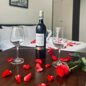 a bottle of wine and two wine glasses on a table at LaBi Hotel n Apartment Danang in Da Nang