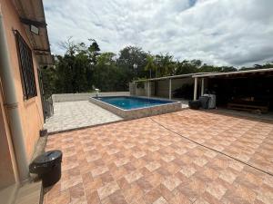a patio with a swimming pool and a house at Chacarra in Mongaguá