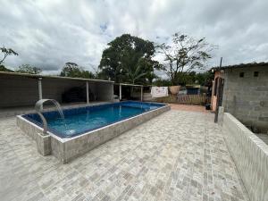 a large swimming pool in a patio with at Chacarra in Mongaguá