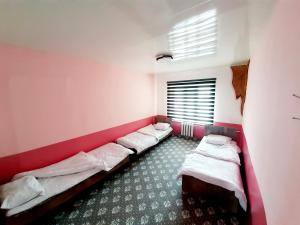 ein Zimmer mit drei Betten und einem Fenster in der Unterkunft Hostel Farko in Andijon + 19 Fotos
