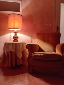 lampa siedząca na stole obok krzesła w obiekcie Garda City Home Family Apartments w mieście Garda