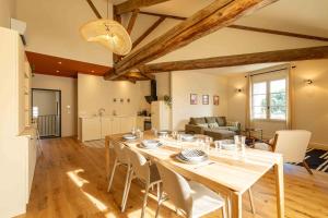 a dining room and living room with a table and chairs at OUSTAU DE MARIE in Saint-Rémy-de-Provence