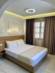 a bedroom with a large bed and a window at Cretan Berry Portou in Chania