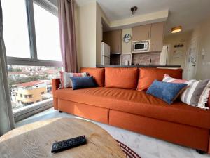 an orange couch in a living room with a window at BE-Berrocal in Málaga +17 photos