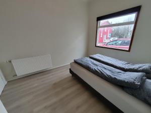 a bedroom with a bed and a window at Cosy 2-bedroom flat in Selfoss +7 photos