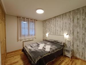 a bedroom with a bed with two towels on it at Apartamento Oreja de Oso Benasque Inmocyma in Benasque