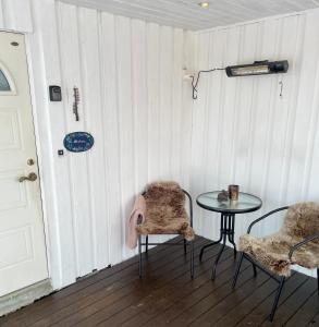 a room with a table and two chairs and a door at Marvelous farmhouse with WiFi in Troms, Northern Norway in Nordøya
