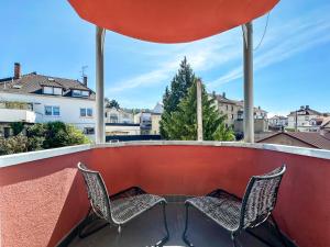 two chairs sitting on a balcony with a view at Saint Maurice Design Home in Stiring-Wendel