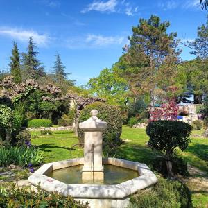 ein Brunnen mitten in einem Garten in der Unterkunft Gîte en Ardèche Méridionale - Les Berbéris in Chandolas