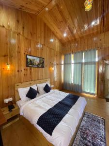 a bedroom with a large bed in a wooden room at The Golden Castle Hotels in Mukteswar