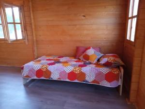 a bedroom with a bed in a wooden room at Centru de activități, retreaturi, fermă in Bicăcel
