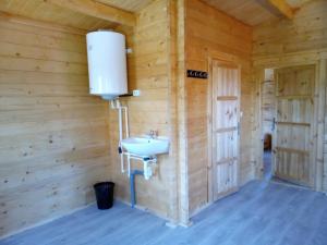 a bathroom in a wooden cabin with a sink at Centru de activități, retreaturi, fermă in Bicăcel
