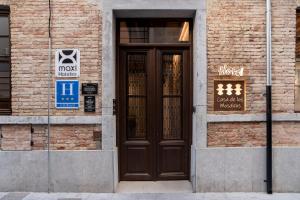 a brown door on the side of a brick building at Hotel La Casa de Los Mosaicos by Maxi Hoteles in Granada