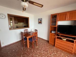 ein Wohnzimmer mit einem Esstisch und einem TV in der Unterkunft Cullera-Apartment in Cullera