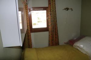 a bedroom with a bed and a window with curtains at Les Capellans, port d'attache in Saint-Cyprien-Plage