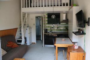 a living room with a loft bed and a kitchen at Les Capellans, port d'attache in Saint-Cyprien-Plage