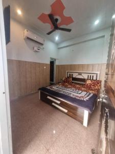 ein Schlafzimmer mit einem Bett und einem Deckenventilator in der Unterkunft Shri Ladli Ji Guest House in Chhatikara