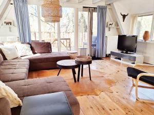 a living room with a couch and a tv at Chalet 139 Hakuna Matata in Durbuy