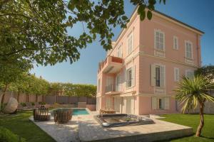 a large pink building with a swimming pool in front of it at FRGK "VILLA La Cote D'Azur" in Cannes