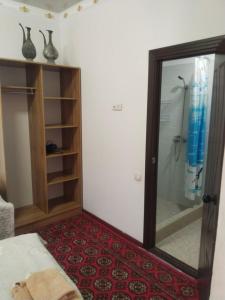 a bedroom with a shower with a glass door at Khiva Mirza Bobur Guest House in Khiva