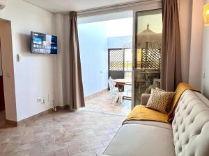 a living room with a couch and a sliding glass door at Refúgio da Ria By ALGARTUR in Cabanas de Tavira