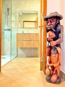 a statue of a man standing in a bathroom at Refúgio da Ria By ALGARTUR in Cabanas de Tavira +25 photos