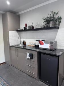 - une cuisine avec un comptoir, un évier et une cuisinière dans l'établissement TheGarden, à Bloemfontein